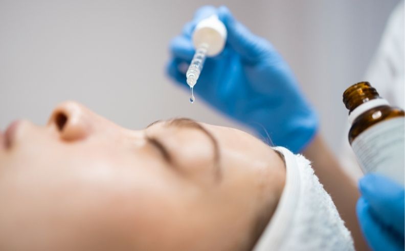 Une jeune femme appliquant de l'acide hyaluronique