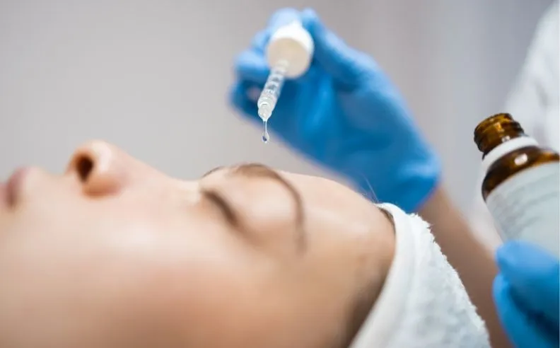 Une jeune femme appliquant de l'acide hyaluronique