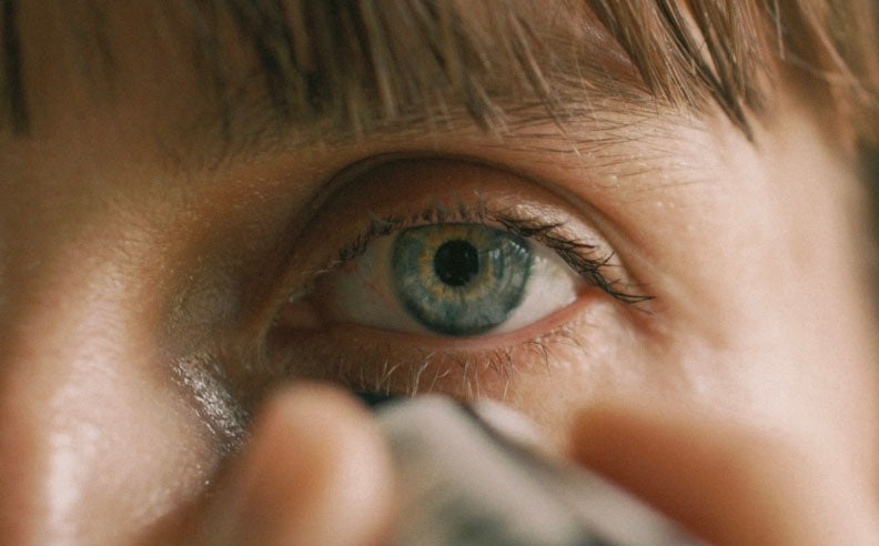 Zoom sur le regard d'une femme qui s'applique l'élixir contour des yeux